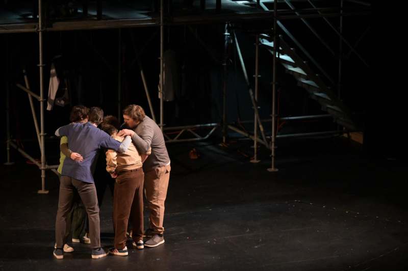 a group of people hugging on a stage
