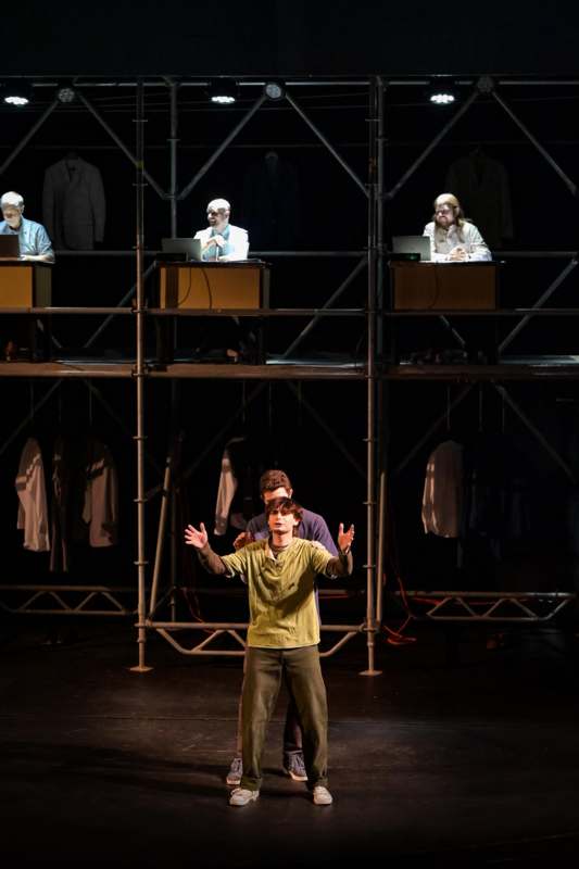 a man on a stage with a man in front of a group of men