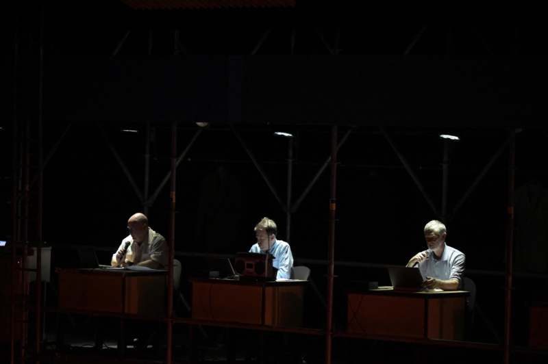 a group of men sitting at desks with laptops