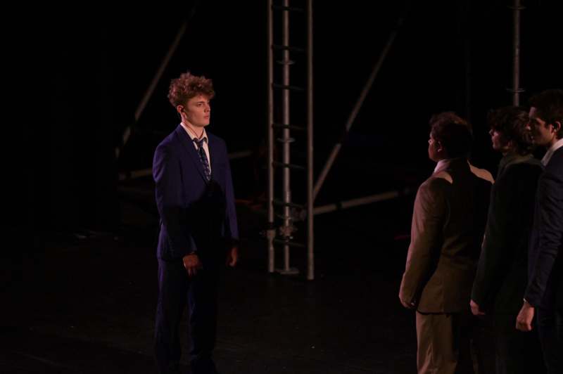 a man in a suit standing next to another man in a suit