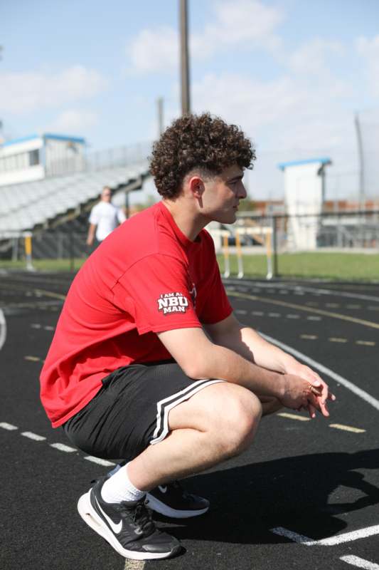 a man squatting on a track