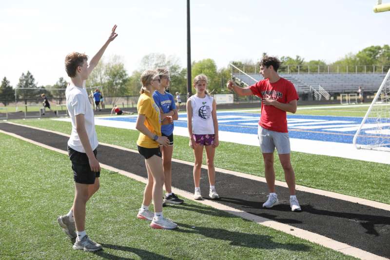 a man pointing at a group of people on a track