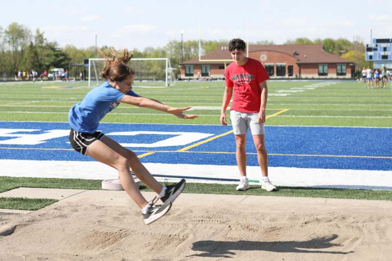 a woman jumping over a long jump