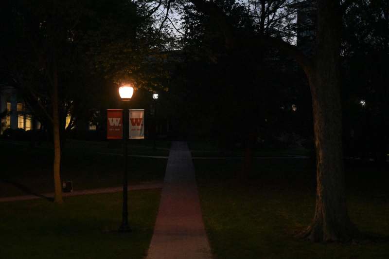 a light post and a path in a park at night