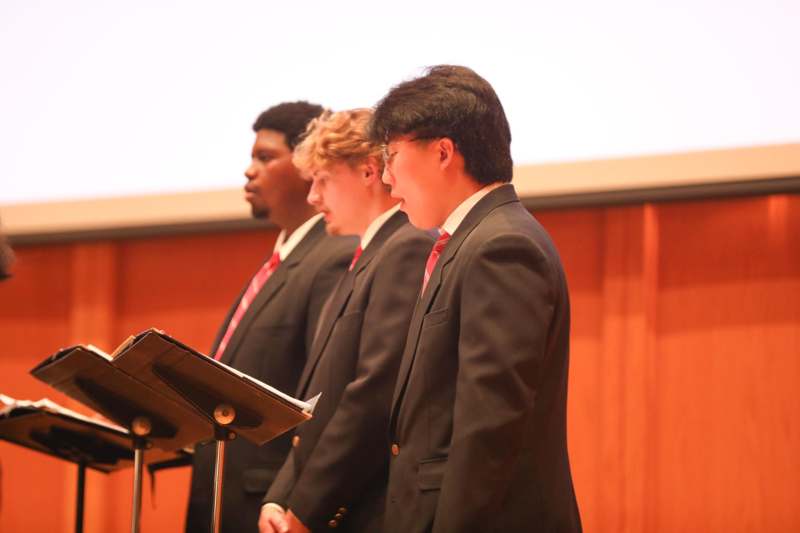 a group of men in suits standing in front of a podium