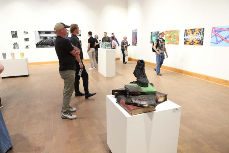 people standing in a room with a group of people looking at a statue
