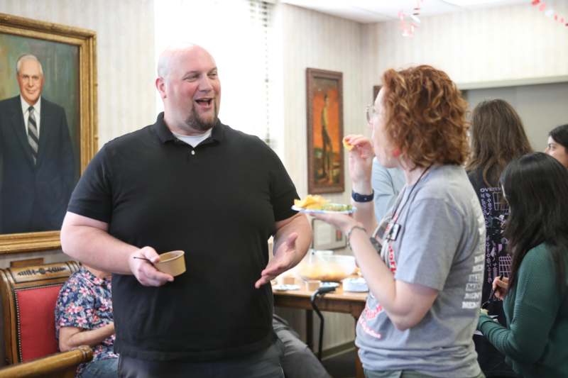 a man standing in a room with a woman holding food
