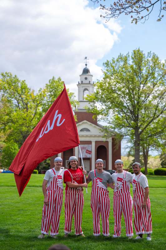a group of people wearing striped shirts and holding a flag