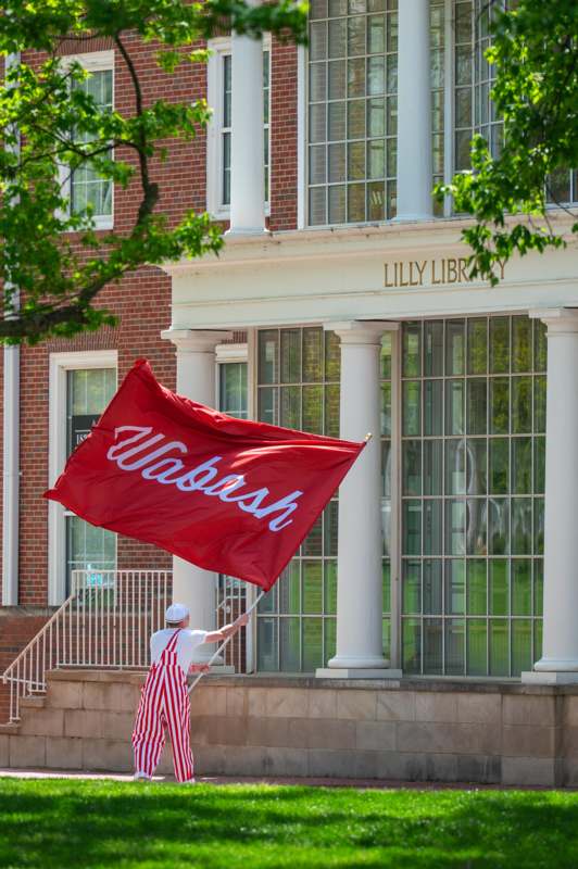 a person holding a flag outside of a building