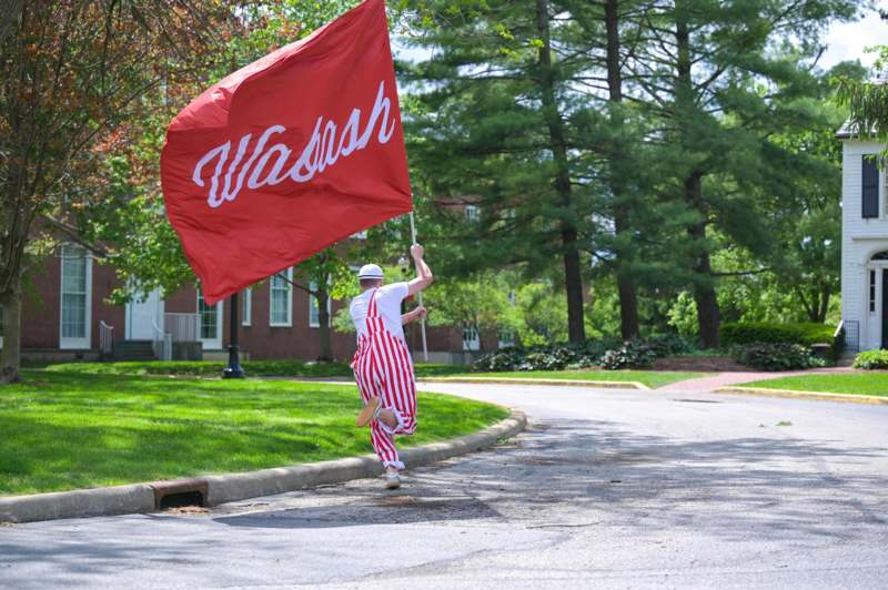 a man running on the street holding a red flag