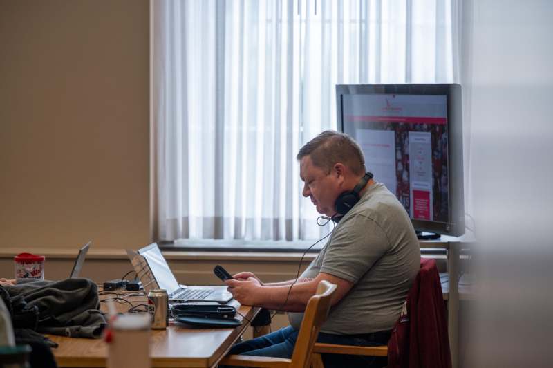 a man sitting at a desk with a laptop and headphones on