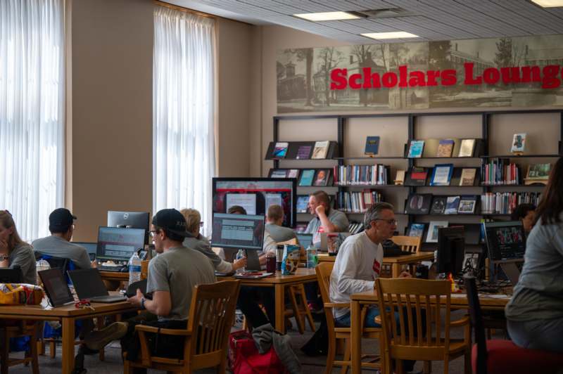 a group of people sitting at tables with computers