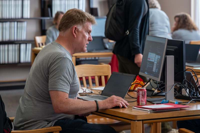 a man sitting at a desk with a laptop