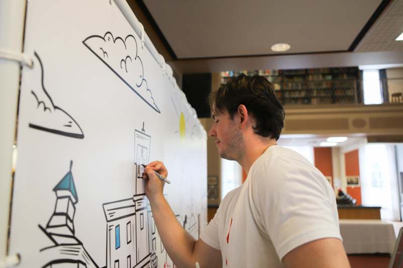 a man drawing on a white board