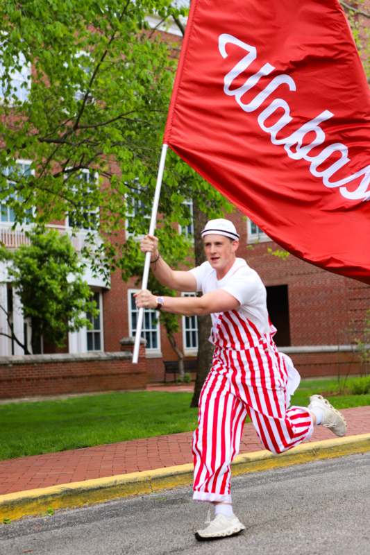 a man running with a red and white striped flag