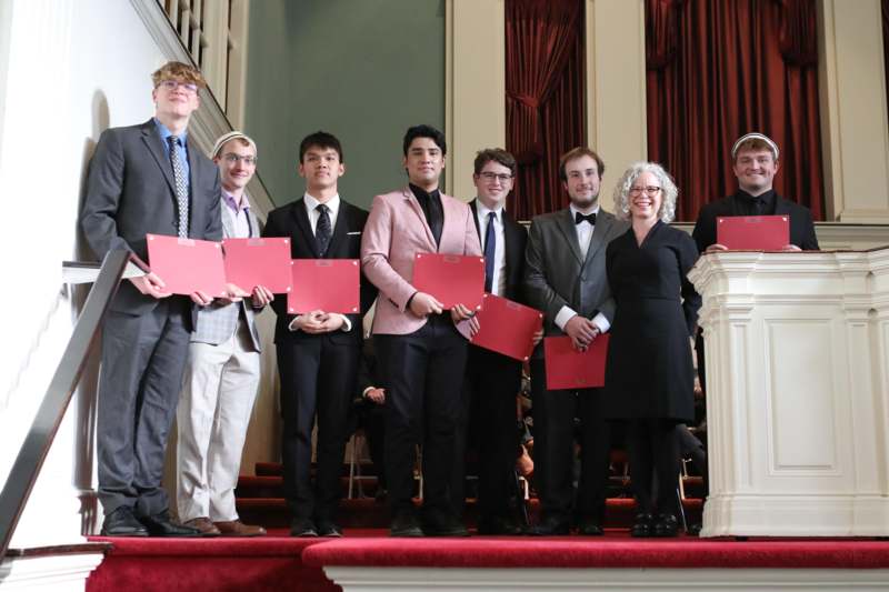 a group of people holding red papers