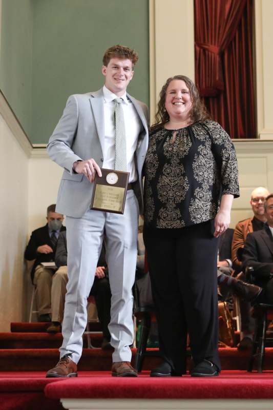 a man and woman standing on stairs with a plaque