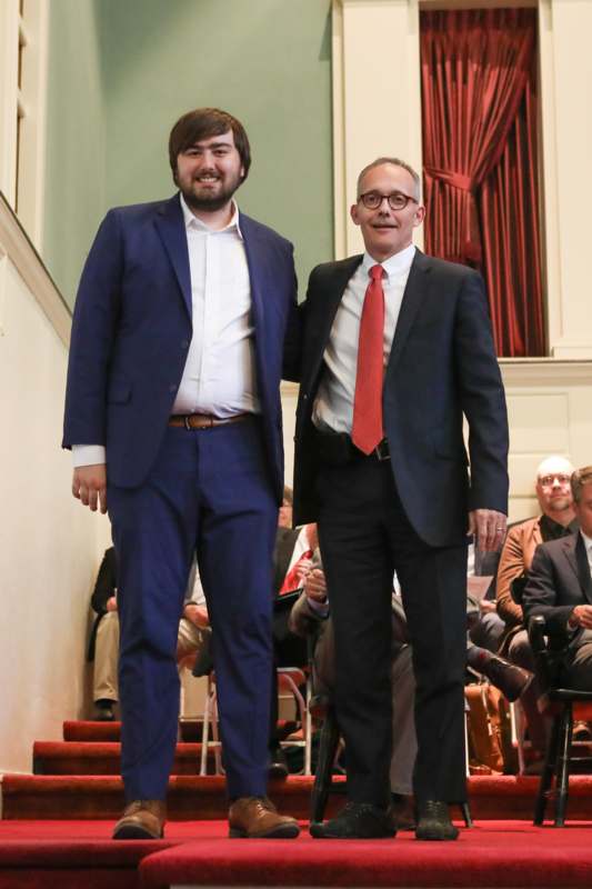 two men in suits standing on stairs