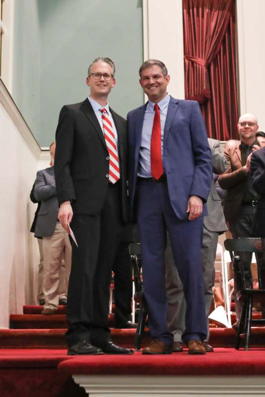 two men in suits standing on stairs
