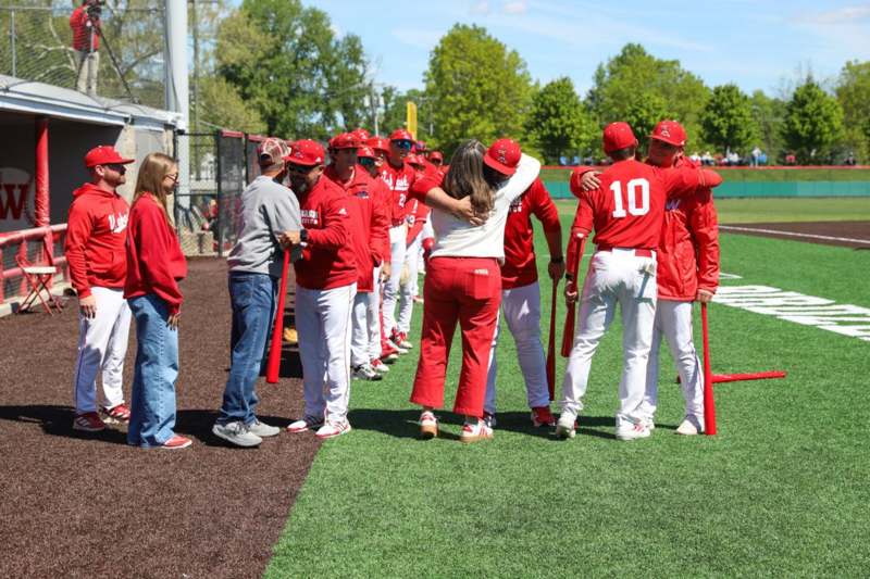 a group of people in red uniforms hugging