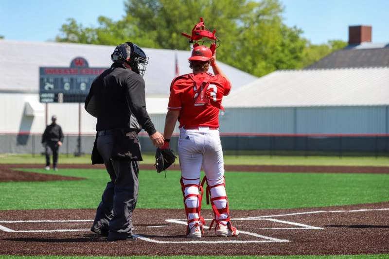 a baseball player holding a helmet