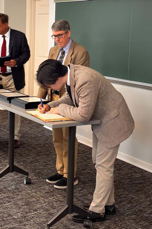 2026 Phi Beta Kappa Induction - a man writing on a book