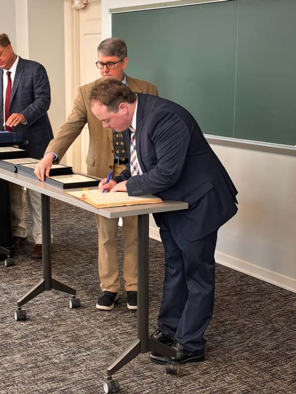a man in a suit writing on a book