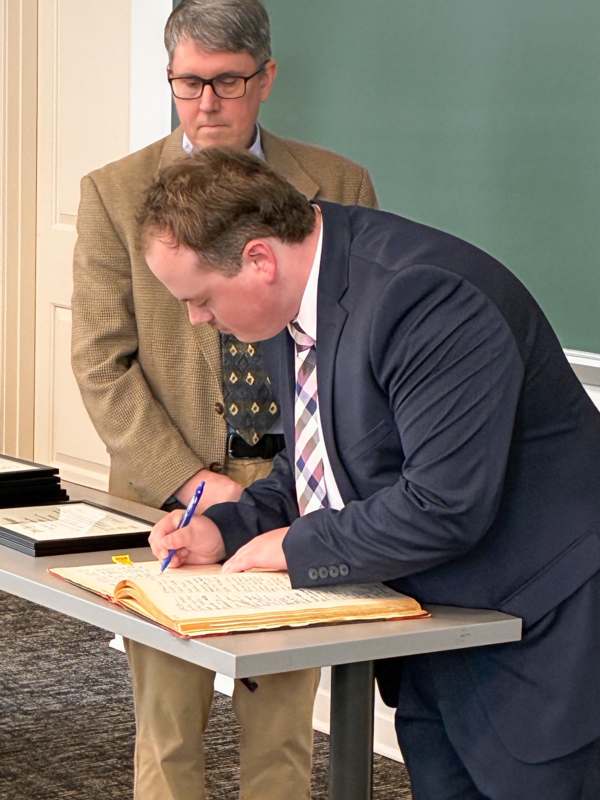 a man in a suit writing on a book