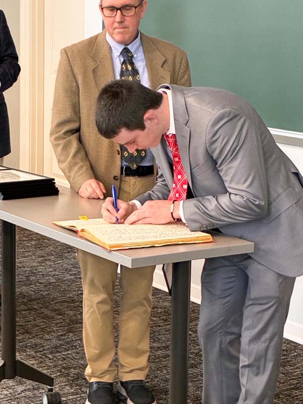a man in a suit writing on a book