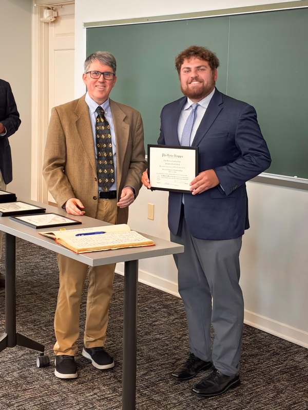 a man holding a certificate and smiling
