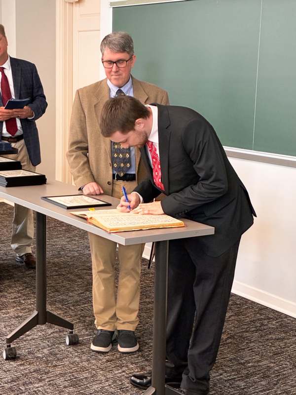 a man in a suit writing on a book
