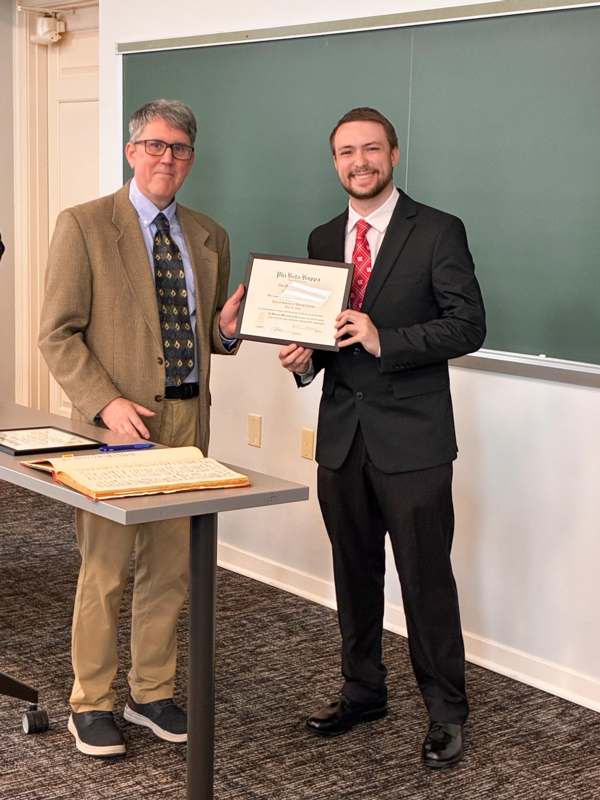 two men in suits holding a certificate