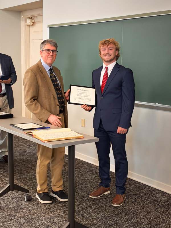 a man holding a certificate and smiling