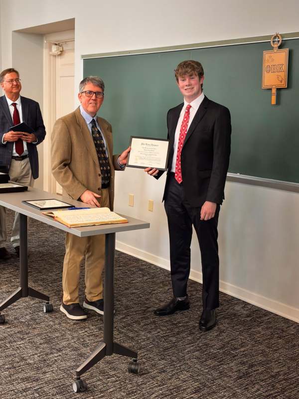 a man in a suit holding a certificate