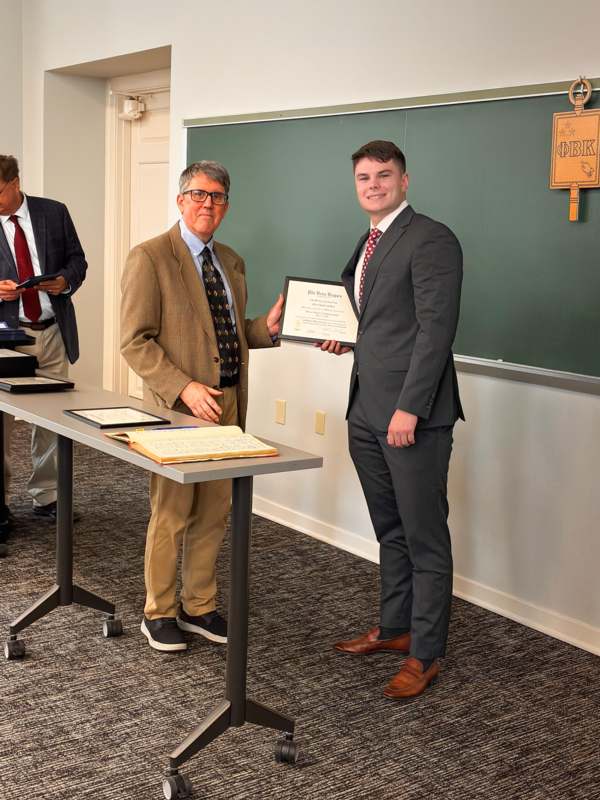 a man holding a certificate and smiling