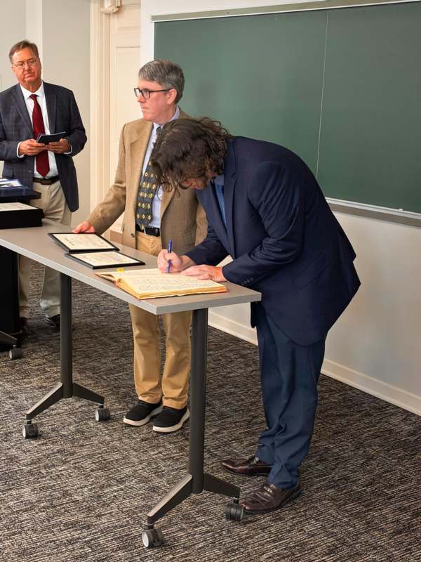 a man in a suit writing on a book