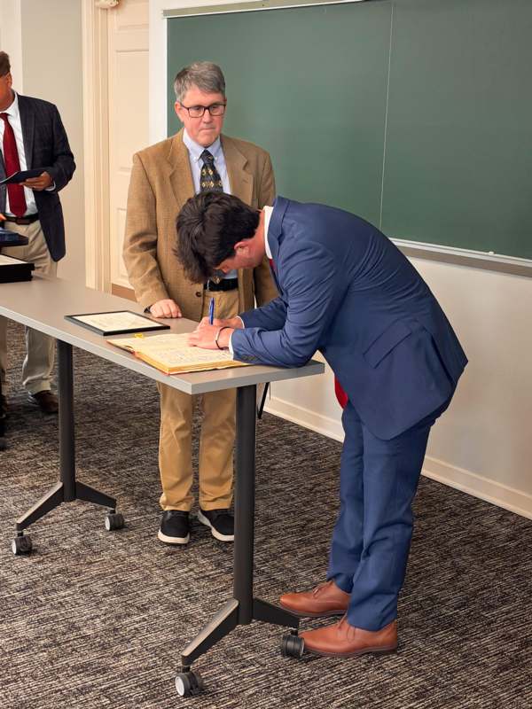 a man in a suit signing a book