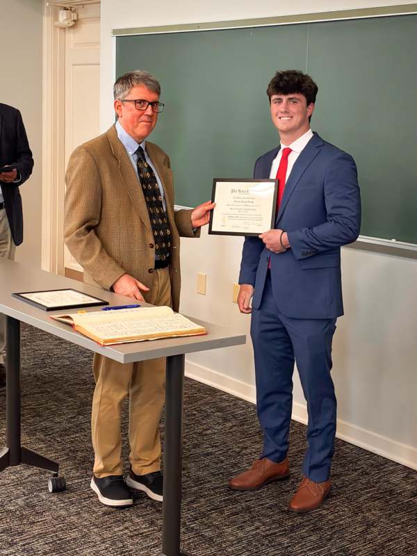 a man holding a certificate and smiling