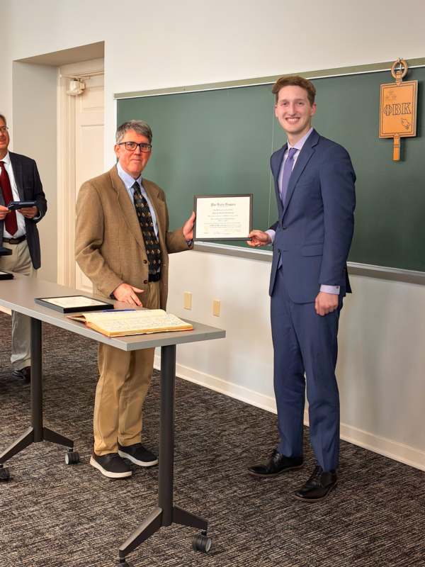 a man in a suit holding a certificate