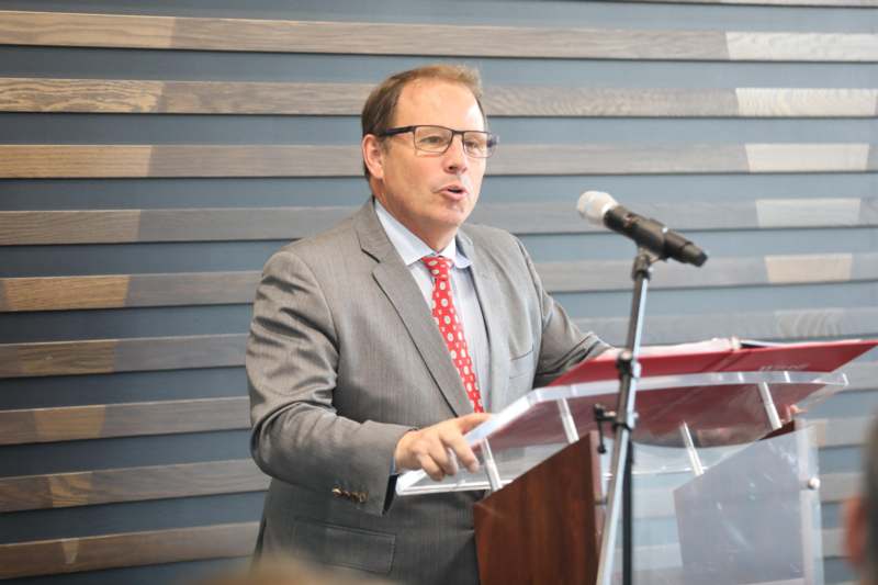 a man standing at a podium speaking into a microphone