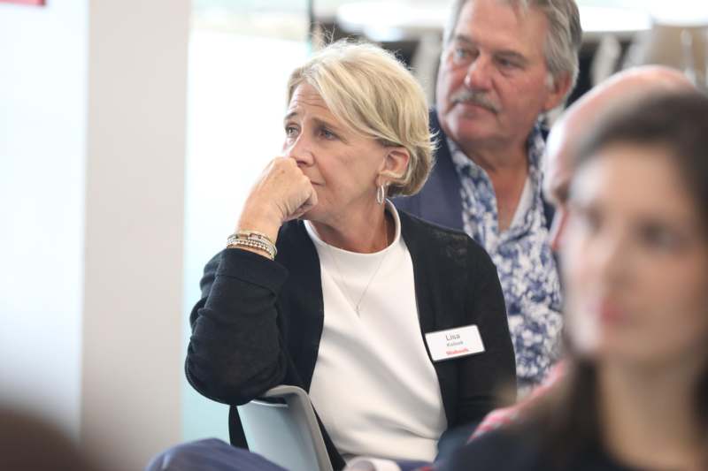 a woman sitting in a chair with her hand on her chin
