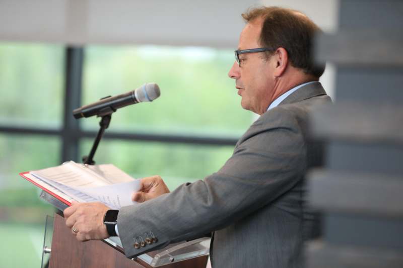 a man in a suit at a podium with a microphone