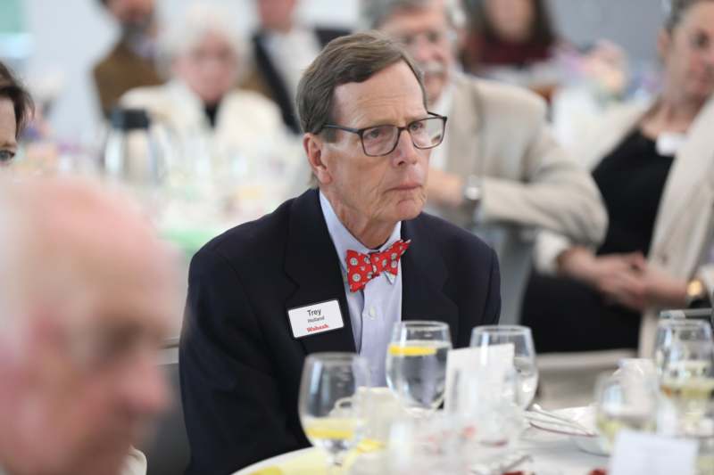a man wearing a bow tie and glasses sitting at a table
