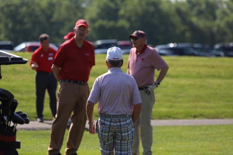 a group of men standing on a golf course