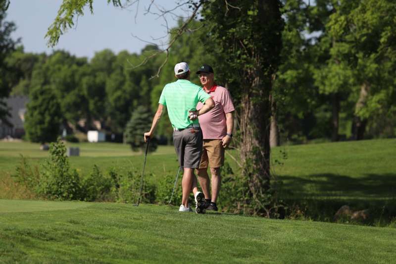 two men walking on a golf course