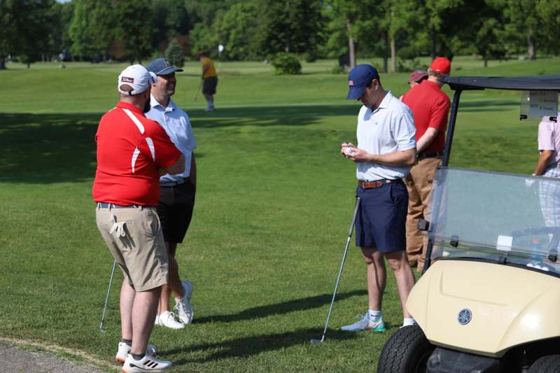a group of men standing on a golf course