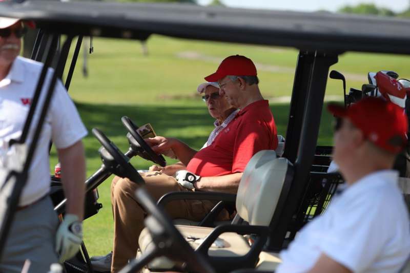 a group of men in golf carts