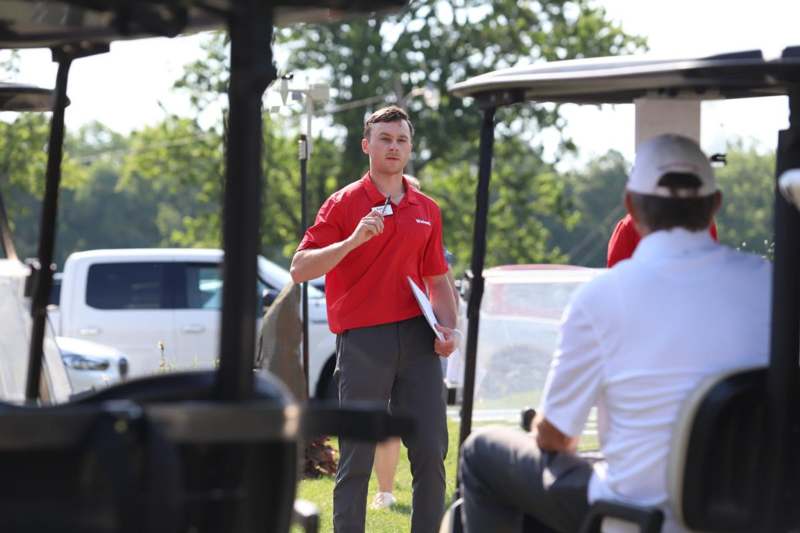 a man holding a clipboard and a man in a red shirt