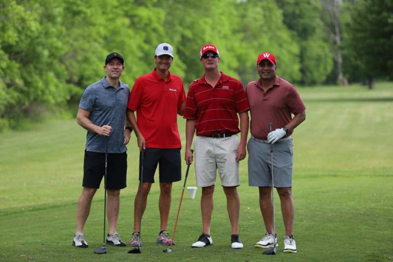 a group of men standing on a golf course