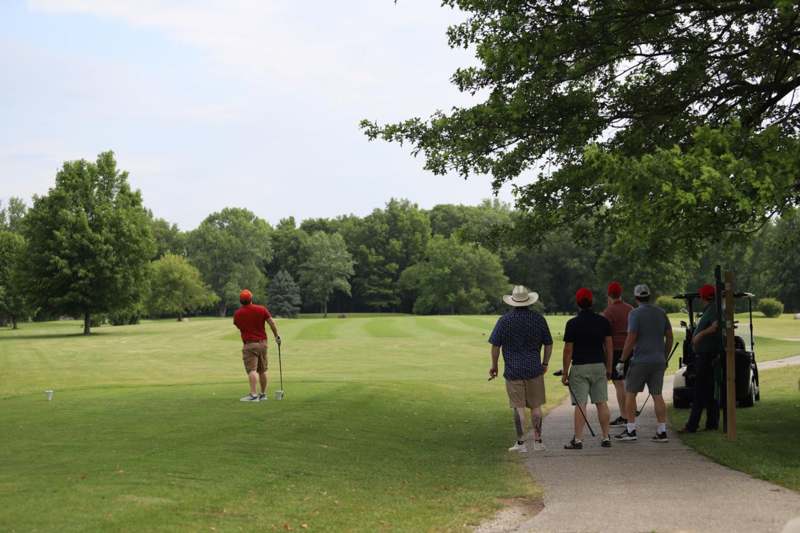 a group of people walking on a golf course